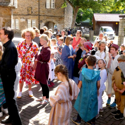 Im Bild sind Teilnehmer und Besucher des Musicals vor der Kirche bei bestem Wetter zu sehen.